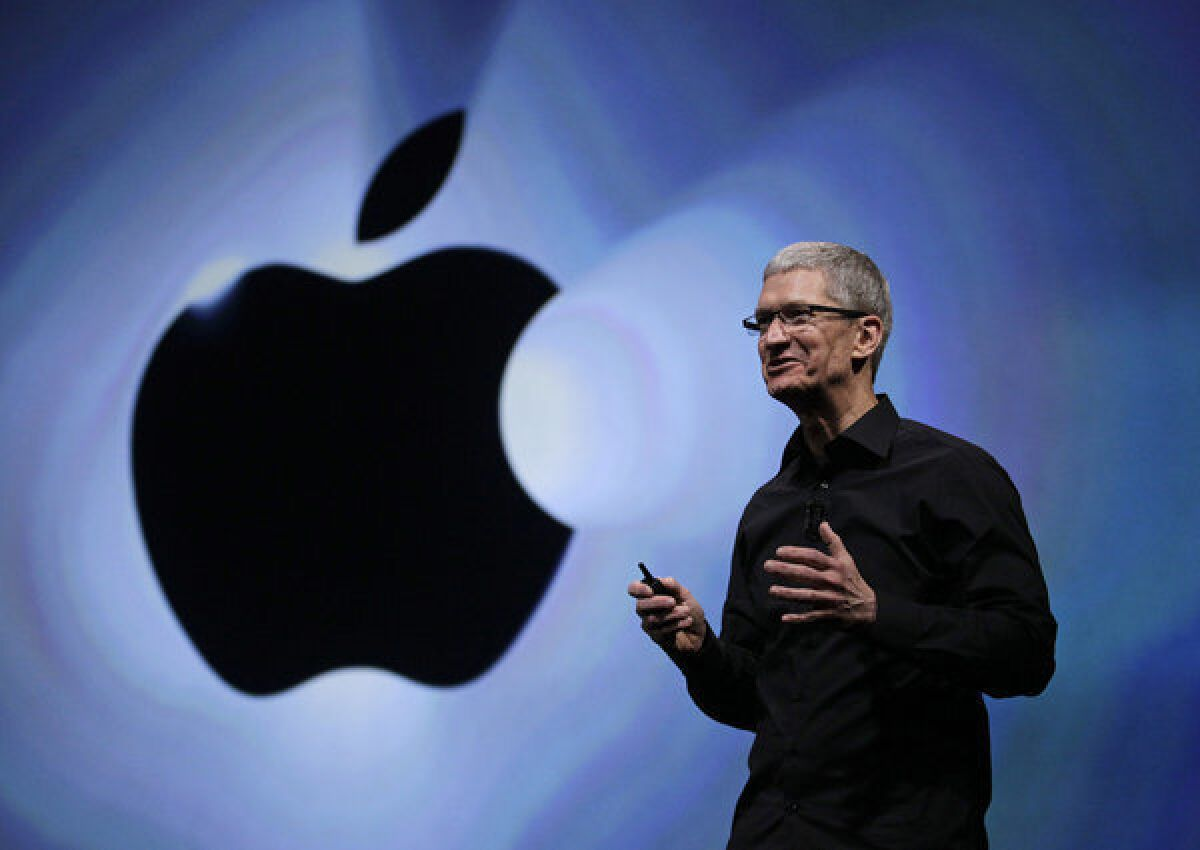 An image showing Tim cook, and behind him is the logo of Apple