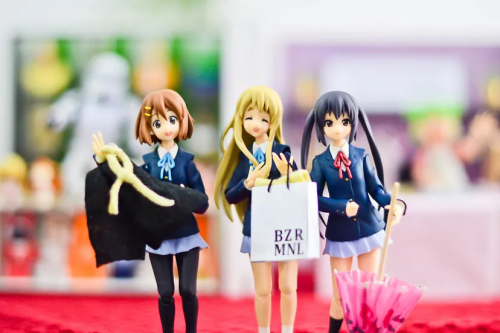 Figures of Yui, Tsumugi, and Azusa from K-On! with a blurred background